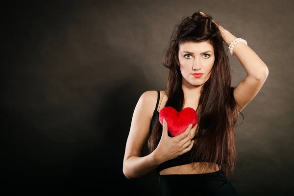 Beautiful woman holds red heart on black — Stock Photo, Image