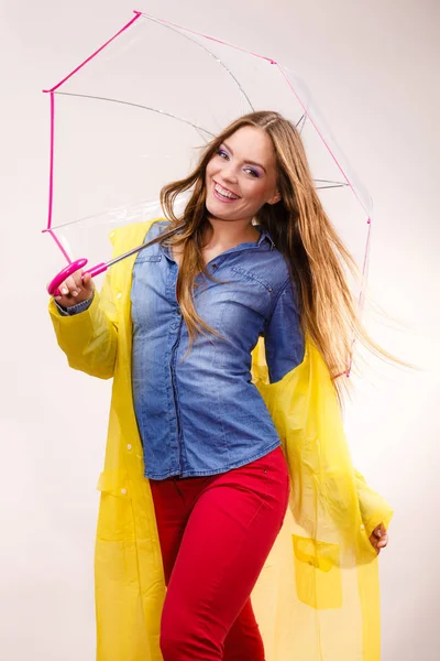 Жінка в водонепроникному пальто під парасолькою — стокове фото