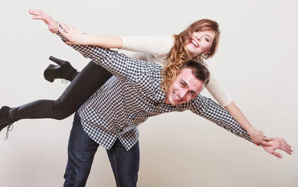 Woman riding piggyback on man. Happy couple. — Stock Photo, Image