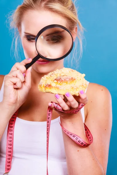 Mujer con lupa examinando comida dulce — Foto de Stock