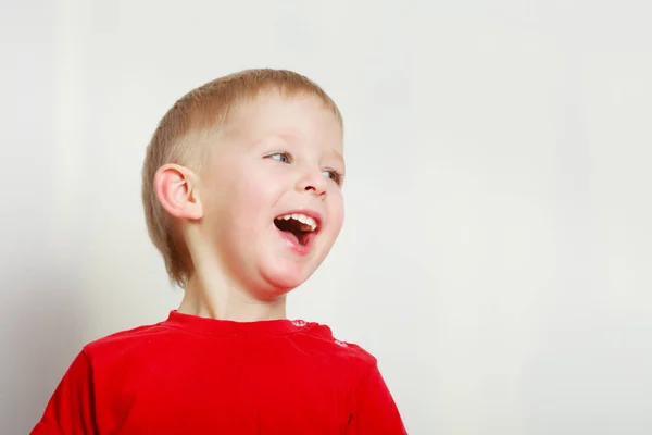 Gelukkig kind jongen maken van grappige dom gezichten — Stockfoto