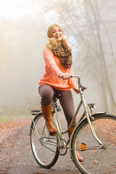 Mujer activa feliz montar en bicicleta en el parque de otoño . —  Fotos de Stock