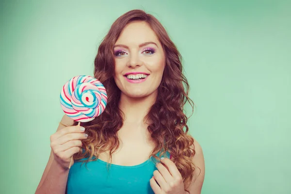 Smiling girl with lollipop candy on teal — Stock Photo, Image