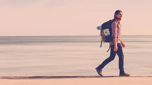 Mann wandert mit Rucksack am Meer entlang — Stockfoto