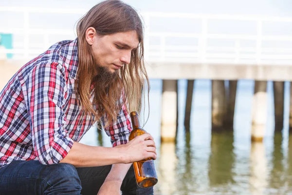 Şarap şişesi kumsalda açık oturma ile depresif adam — Stok fotoğraf
