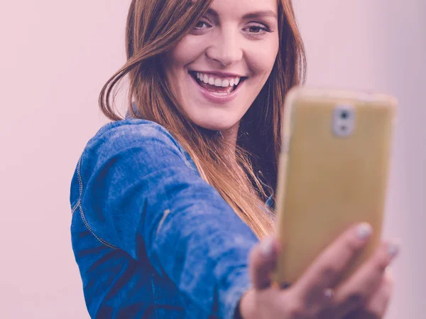 Женщина в джинсовой рубашке фотографируется с телефоном — стоковое фото