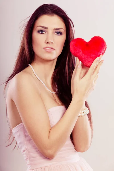 Schöne Frau hält rotes Herz — Stockfoto