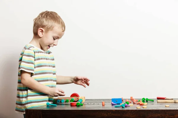 Vista lateral menino brincar com brinquedo na mesa . — Fotografia de Stock