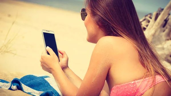 Mujer en la playa mensajes de texto en el teléfono inteligente . —  Fotos de Stock