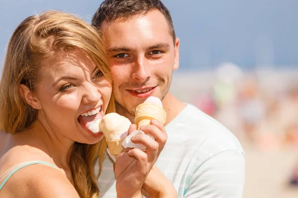 Mężczyzna i kobieta jedzący lody na plaży — Zdjęcie stockowe