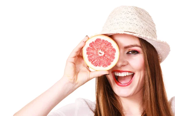 Menina cobrindo os olhos com duas metades de frutas cítricas de toranja — Fotografia de Stock
