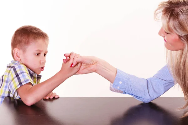 Mother and son arm wrestle sit at table. — Stock Photo, Image