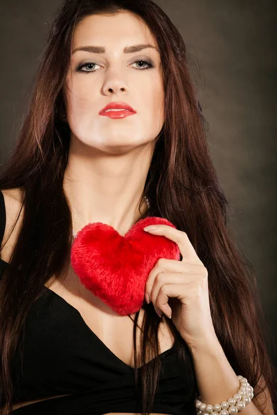 Όμορφη γυναίκα κατέχει κόκκινη καρδιά πάνω σε μαύρο — Φωτογραφία Αρχείου