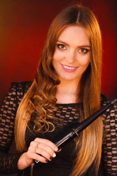 Happy woman curling her long brown hair — Stock Photo, Image