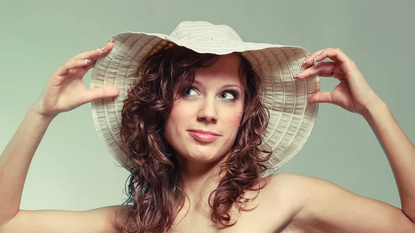 Mladá žena úsměv a touch klobouk. — Stock fotografie