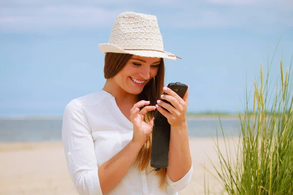 Kvinna på stranden sms på smartphone. — Stockfoto