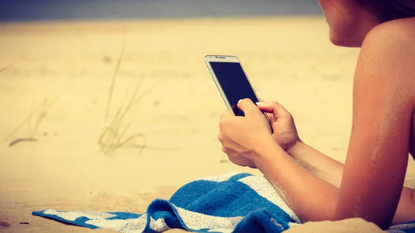 Femme sur la plage textos sur smartphone. — Photo