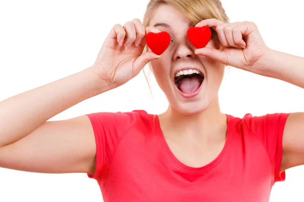Mujer divertida sostiene corazones rojos sobre los ojos —  Fotos de Stock