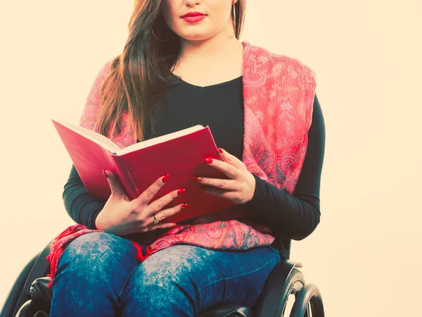Junge behinderte Frau im Rollstuhl mit Buch. — Stockfoto