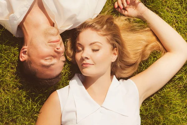 Мужчина и женщина, лежащие на траве, встречаются — стоковое фото