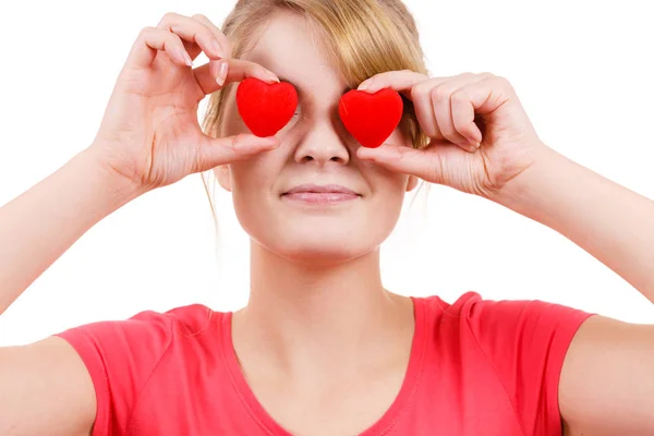 Смішна жінка тримає червоні серця над очима — стокове фото