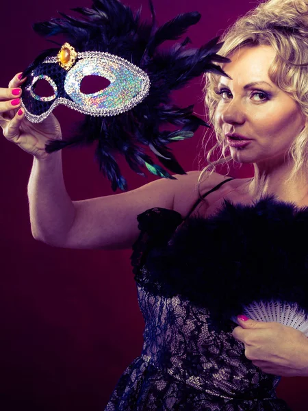 Kvinnan håller carnival mask fjäder solfjäder i hand — Stockfoto