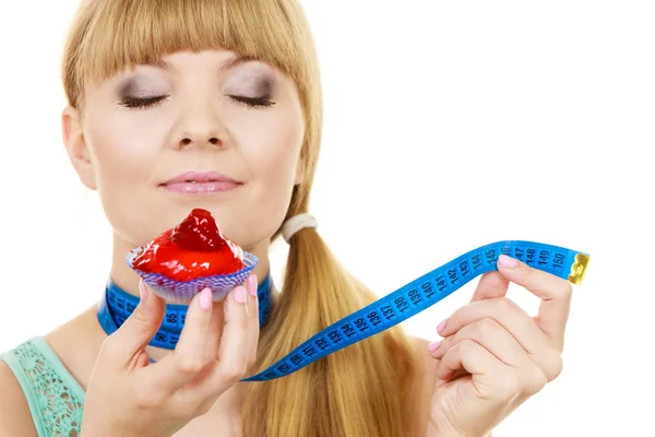 Donna tiene cupcake cercando di resistere alla tentazione — Foto Stock