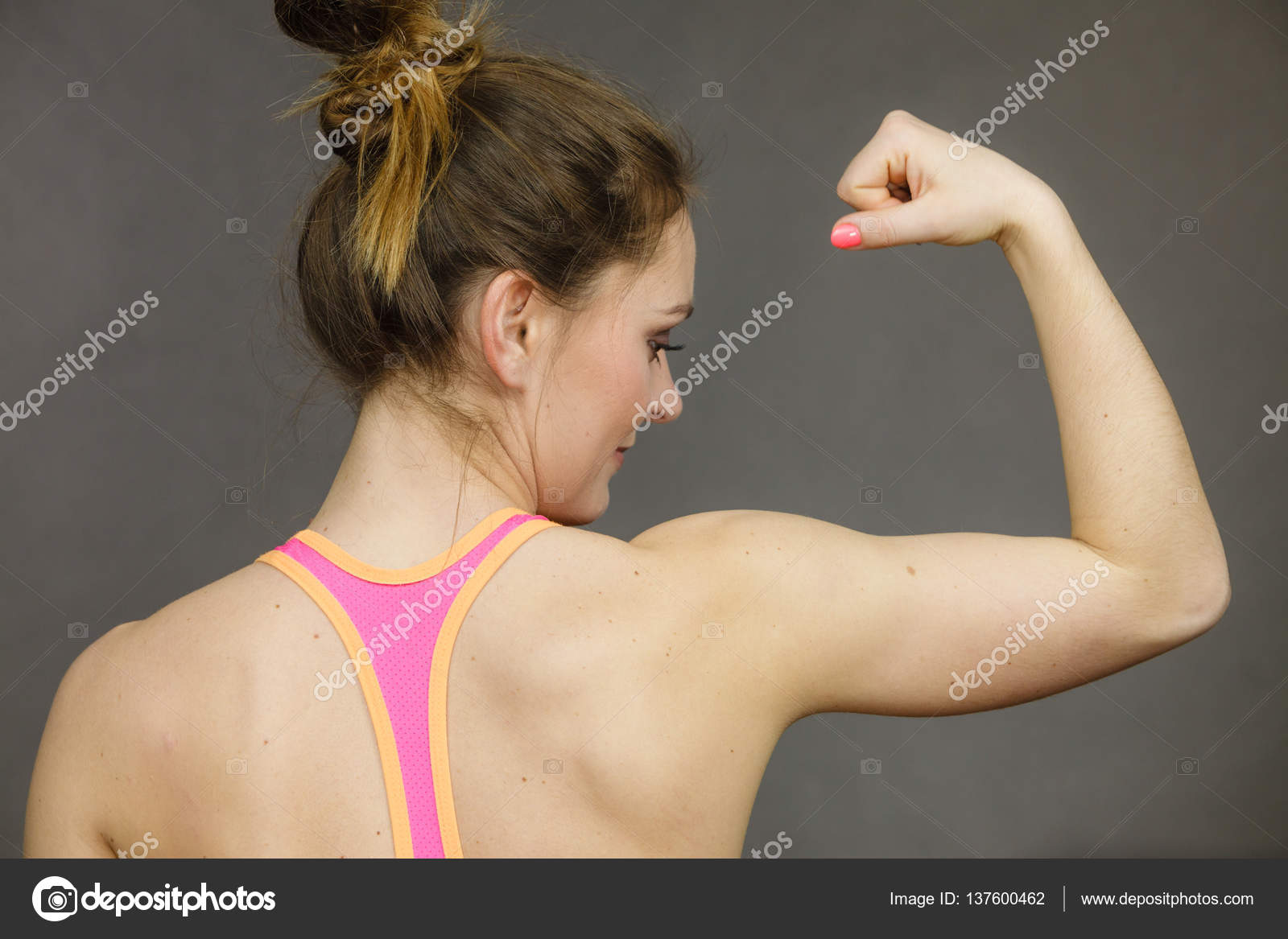 Woman showing muscles of the back and shoulders Stock Photo by ©Voyagerix  137600462