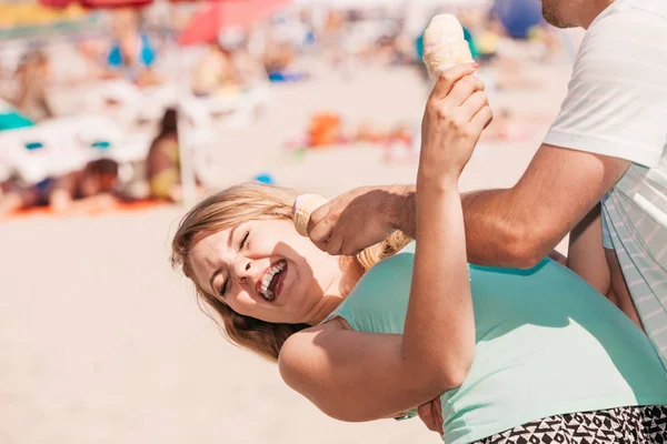 Mężczyzna i kobieta jedzący lody na plaży — Zdjęcie stockowe