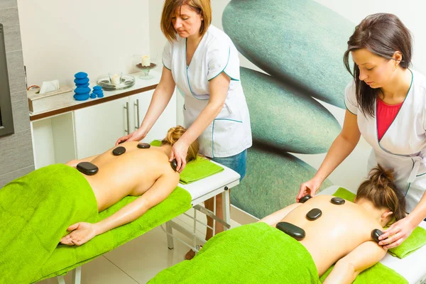 Massage mit heißen Steinen in Kosmetikerin — Stockfoto