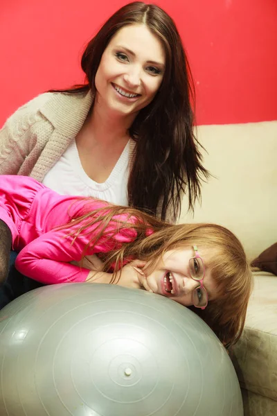 Mãe sentada na bola de exercício com a filha — Fotografia de Stock