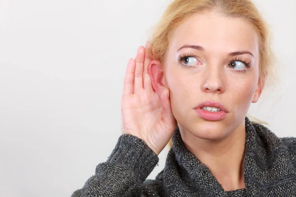 Woman put hand to ear for better hearing Stock Picture