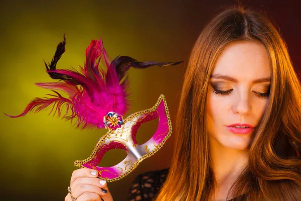 Beautiful girl holds carnival mysterious mask. — Stock Photo, Image