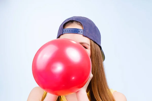 Mujer adolescente inflando globo rojo . — Foto de Stock