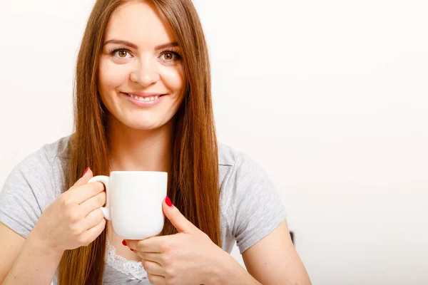 Souriant jeune femme tenant une tasse de thé — Photo