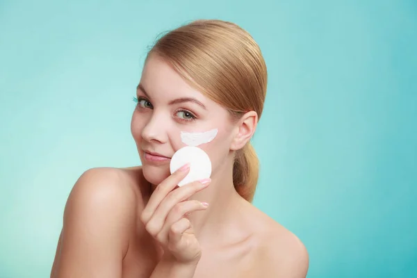 Mujer quitando maquillaje con crema y almohadilla de algodón — Foto de Stock