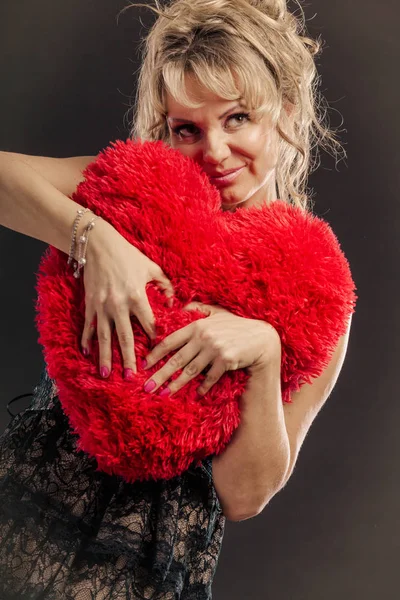 Madura mujer abrazo grande rojo corazón —  Fotos de Stock