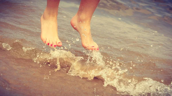 Pies femeninos saltar en la playa . — Foto de Stock