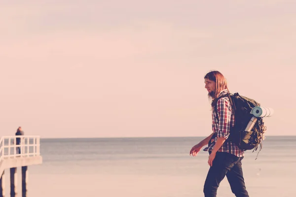 男性ハイカーのバックパックを海辺で山歩き — ストック写真