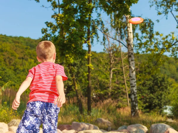 Mały chłopiec bawi frisbee dysk. — Zdjęcie stockowe