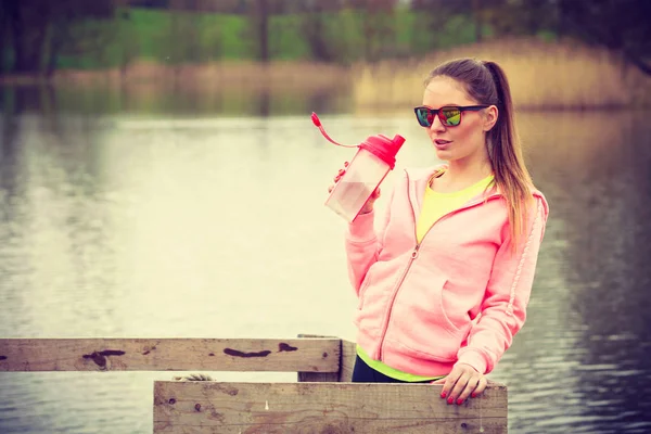 Mujer con botella de agua después de hacer ejercicio — Foto de Stock