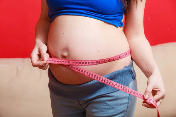 Pregnant woman measuring her belly close up — Stock Photo, Image