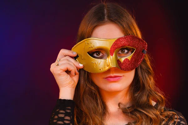 Närbild kvinna ansikte med carnival gyllene röd mask på mörk — Stockfoto