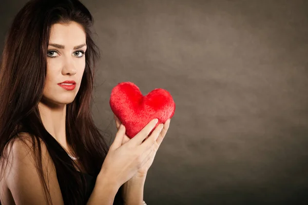 Женщина держит красное сердце на черном — стоковое фото