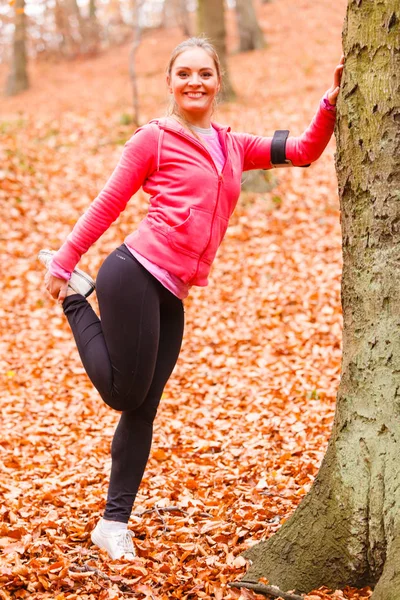 Dynamische meisje die zich uitstrekt in bos. — Stockfoto