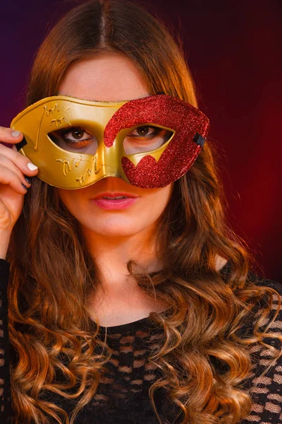 Cara de mujer de primer plano con carnaval máscara roja dorada en la oscuridad —  Fotos de Stock