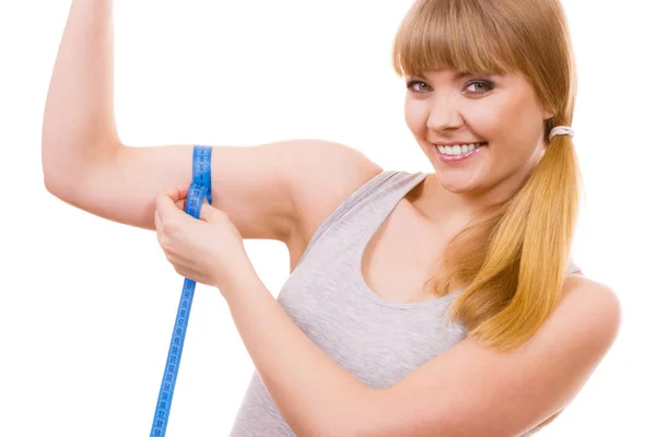 Fit menina com fita métrica medindo seu bíceps — Fotografia de Stock