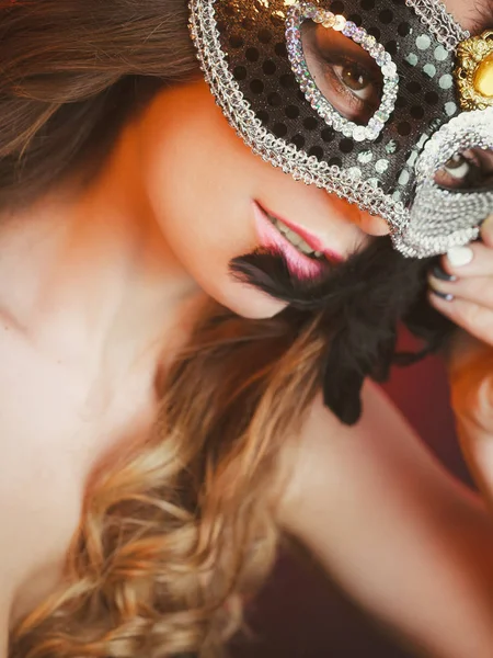 Close-up vrouw gezicht met carnaval masker op donker Stockfoto