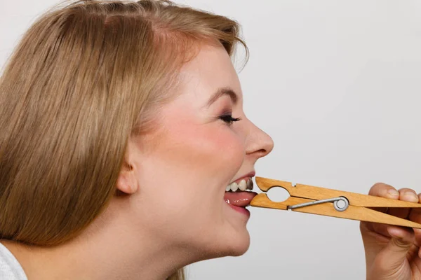 Mujer rubia teniendo lengua en pinza de ropa — Foto de Stock