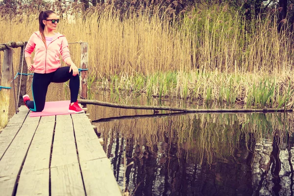 Chica de entrenamiento en ropa deportiva en la orilla del lago — Foto de Stock